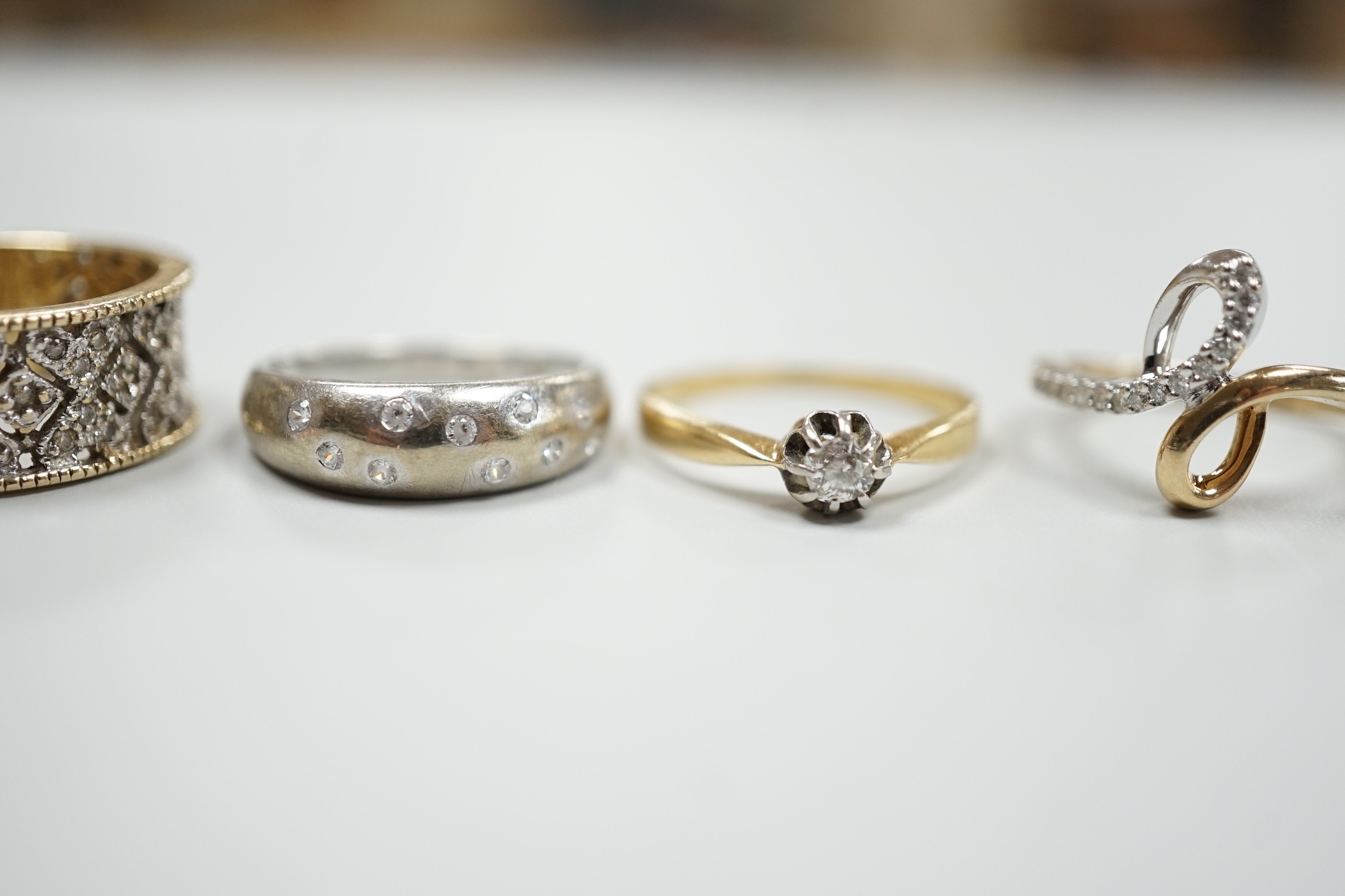 Three modern 9ct gold and diamond chip set rings and a yellow metal and solitaire diamond set ring, gross weight 12.4 grams.